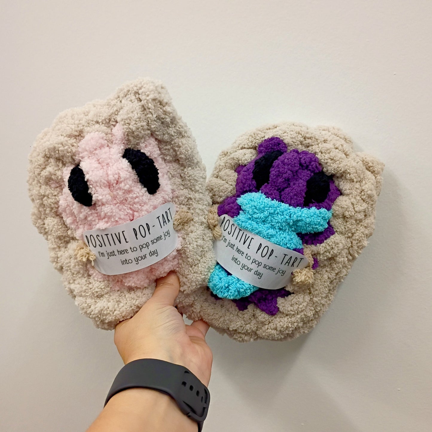 Positive Pop-Tart Plush — handmade knitted plush in pink and purple colorways with positive tag