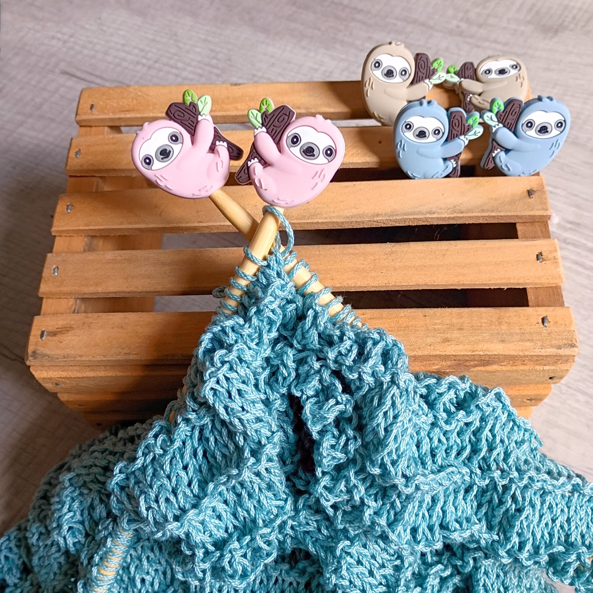 Sloth Knitting Needle Stoppers — pink, blue, and beige sloth silicone stoppers on bamboo knitting needles