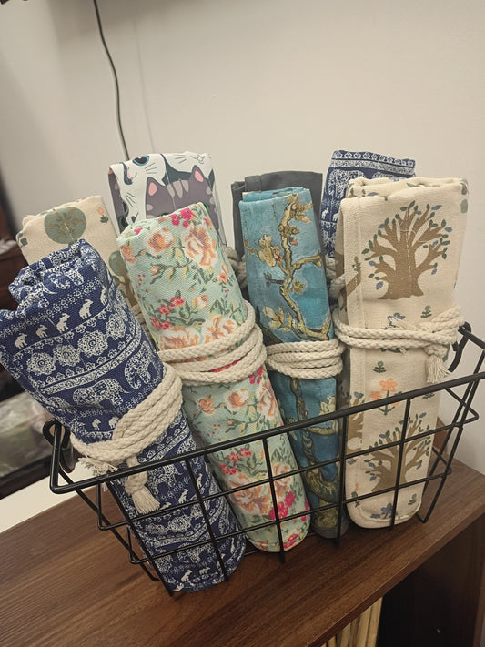 Canvas roller storage bags in various patterns displayed in a wire basket